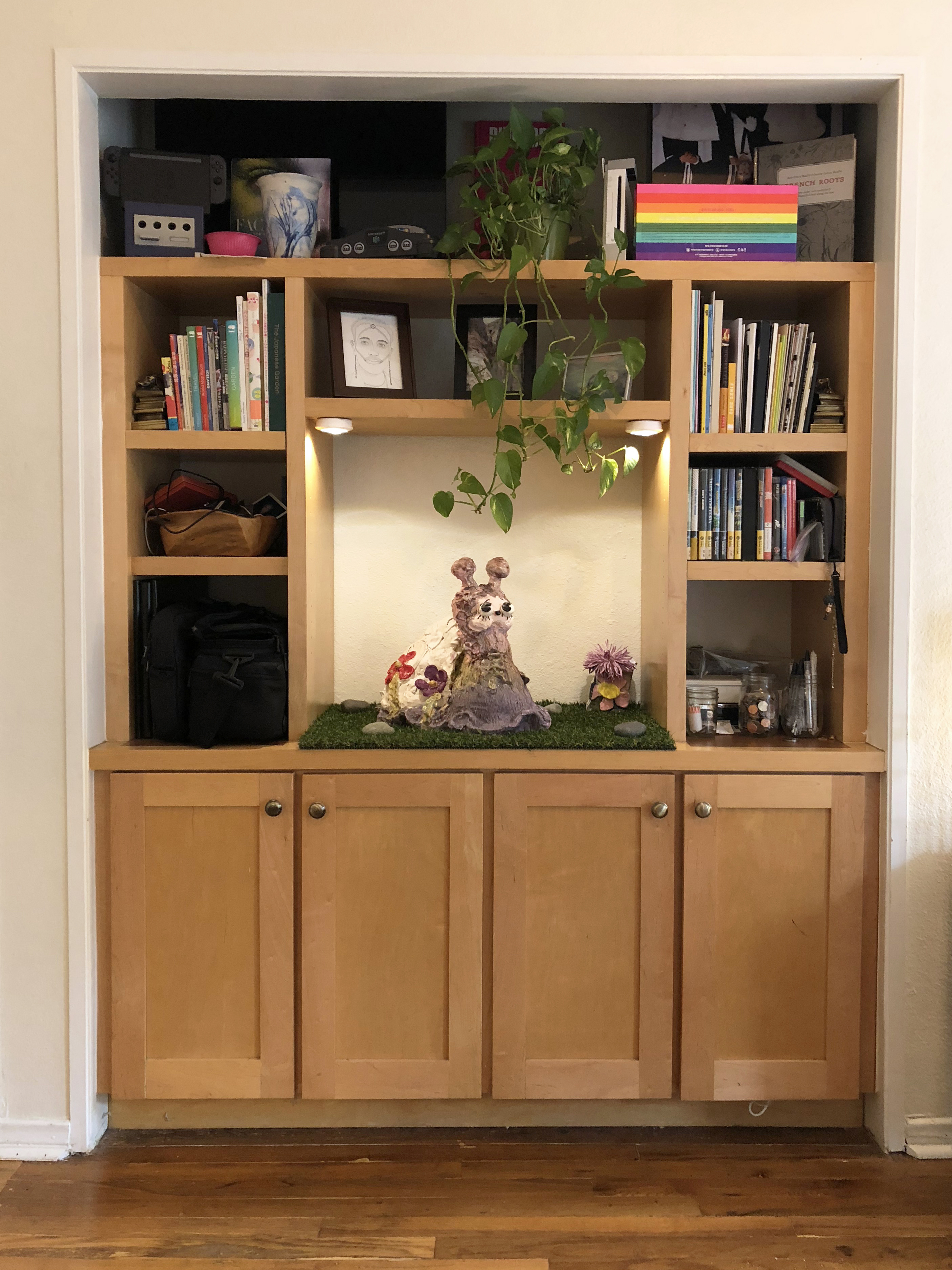 A built in entertainment center with a large ceramic snail sculpture in the center